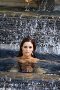 Jayden Cole is a vision as she dramatically emerges from beneath the pool's surface, sparkling...